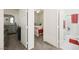 A hallway with neutral carpet leads to a bedroom, which opens to a bathroom with red heart-themed towels at 984 Brilliant Meadow Ave, North Las Vegas, NV 89086