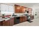 Well-lit kitchen with dark wood cabinets, granite countertops, and stainless steel appliances at 984 Brilliant Meadow Ave, North Las Vegas, NV 89086