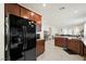 Open kitchen concept featuring dark wood cabinets, granite countertops, and stainless steel appliances at 984 Brilliant Meadow Ave, North Las Vegas, NV 89086