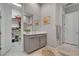 Neutral-toned bathroom features a vanity with a mirror, cabinets, and a view into a closet at 10001 Regency Square Ave, Las Vegas, NV 89148