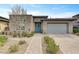 Stunning single-story home with a well-manicured front yard, stone accents, and a charming blue entry door at 10001 Regency Square Ave, Las Vegas, NV 89148