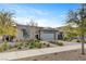 Charming single-story home with desert landscaping and gray two-car garage, complemented by green trees and a clear blue sky at 10001 Regency Square Ave, Las Vegas, NV 89148