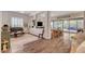 Spacious living room featuring wood floors, a piano, modern furniture and backyard access through large sliding glass doors at 10001 Regency Square Ave, Las Vegas, NV 89148