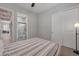 Bedroom leading to the bathroom, plush carpet, a ceiling fan and plantation shutters on the window at 10197 Copper Meadow Ave, Las Vegas, NV 89166