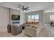 Cozy living room features a modern fireplace, ceiling fan, and large windows with neighborhood views at 10197 Copper Meadow Ave, Las Vegas, NV 89166