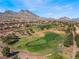 Gorgeous aerial view of the community golf course, lush fairways, mature trees and mountain backdrop at 10508 Snyder Ave, Las Vegas, NV 89134