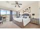 Spacious bedroom featuring a ceiling fan, neutral color palette, and sliding glass door to a balcony with a view at 10548 Nantucket Ridge Ave, Las Vegas, NV 89166