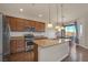Bright kitchen with wood cabinets, stainless steel appliances, granite countertops, and a cozy dining area at 10548 Nantucket Ridge Ave, Las Vegas, NV 89166
