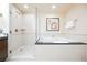 Bright bathroom featuring tiled floors, a glass shower, a tub, and modern fixtures at 135 E Harmon Ave # 1919, Las Vegas, NV 89109