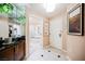Inviting hallway featuring black and white tile, opening to a bathroom with a tub, vanity and front door at 135 E Harmon Ave # 1919, Las Vegas, NV 89109