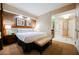 Bedroom with king bed, bench, and a view to the bathroom with a mirrored wet bar at 145 E Harmon Ave # 2503, Las Vegas, NV 89109