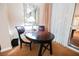 Close up of a dark wood dining table with seating and a view from the window to the outside at 145 E Harmon Ave # 2503, Las Vegas, NV 89109