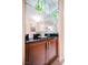 Wet bar with dark wood cabinets, granite counters, mirrored wall and overhead lighting at 145 E Harmon Ave # 2503, Las Vegas, NV 89109