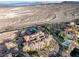 Expansive aerial view of a lakeside community featuring terracotta roofs, community pool and tennis courts at 15 Via Mantova # 303, Henderson, NV 89011