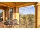 Balcony overlooking desert trees and distant mountains. Seating area, tiled floor, and stucco pillars at 15 Via Mantova # 303, Henderson, NV 89011