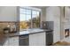 Bright kitchen featuring a stainless steel dishwasher, white cabinets and a view of the mountains at 15 Via Mantova # 303, Henderson, NV 89011