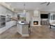 Modern kitchen with center island, stainless appliances, gas cooktop, and view to fireplace and living area at 15 Via Mantova # 303, Henderson, NV 89011
