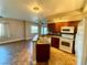 Open concept kitchen overlooking living area, featuring dark wood cabinets, tile floors, and appliances at 1501 Lake Placid Ter # 0, Henderson, NV 89014