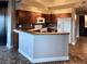 Modern kitchen featuring dark wood cabinets, tiled floors, stone countertops, and white appliances at 1501 Lake Placid Ter # 0, Henderson, NV 89014