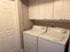Bright laundry room features a washer and dryer with overhead cabinets at 1501 Lake Placid Ter # 0, Henderson, NV 89014