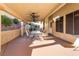 Covered patio with outdoor dining setup and ceiling fans offers a relaxing retreat in the backyard at 1744 Marshall Dr, Henderson, NV 89014