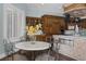 Eat-in kitchen with stainless steel appliances, rustic wood cabinetry, a decorative table, and white marble countertops at 1901 Rosemere Ct, Las Vegas, NV 89117
