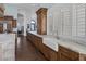 Kitchen with custom cabinets, marble countertops, farmhouse sink, and shuttered windows overlooking the backyard at 1901 Rosemere Ct, Las Vegas, NV 89117