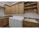 Laundry room features new washer and dryer, utility sink, and wooden cabinets at 1901 Rosemere Ct, Las Vegas, NV 89117
