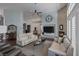 Bright living room with a stone fireplace, ceiling fan, high ceilings, and large windows with shutters at 1901 Rosemere Ct, Las Vegas, NV 89117