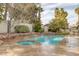 Backyard featuring a sparkling pool, spa, built-in grill, and lush desert landscaping at 1901 Rosemere Ct, Las Vegas, NV 89117
