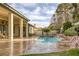 Backyard featuring a sparkling pool, spa, covered patio, and lush landscaping for relaxation at 1901 Rosemere Ct, Las Vegas, NV 89117