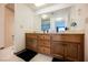 Bathroom vanity with wood cabinets, white countertops and a large mirror at 2004 Canterbury Dr, Las Vegas, NV 89119