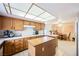 Spacious kitchen with wooden cabinetry, a central island, tile countertops, and adjacent breakfast nook area at 2004 Canterbury Dr, Las Vegas, NV 89119