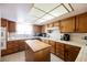 Well-lit kitchen boasts ample wood cabinetry, white tile countertops and backsplash, and a functional center island at 2004 Canterbury Dr, Las Vegas, NV 89119