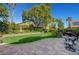 Manicured backyard with a vibrant lawn, mature trees, and a brick-paved patio area at 2236 Midvale Ter, Henderson, NV 89074