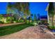 Expansive backyard featuring a lush lawn, decorative landscaping, and a charming patio seating area at 2236 Midvale Ter, Henderson, NV 89074