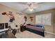 This neutral bedroom has a single bed, ceiling fan, and fun Patriots football wall decor at 2236 Midvale Ter, Henderson, NV 89074