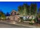 Charming stucco two-story home with a three car garage and manicured landscaping in the front yard at dusk at 2236 Midvale Ter, Henderson, NV 89074