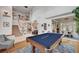 An open-concept living space with a pool table, staircase, chandelier, and elegant decor at 2236 Midvale Ter, Henderson, NV 89074