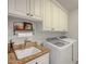 Bright laundry room equipped with granite counters, sink, and modern washer and dryer at 2236 Midvale Ter, Henderson, NV 89074