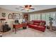 This living room has a red couch, plantation shutters, and plenty of natural light at 2236 Midvale Ter, Henderson, NV 89074