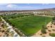 An aerial view of a well-maintained community field, lined with trees, sidewalks and streetlights with homes in the background at 2336 Indigo Island St, Henderson, NV 89044