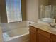 Bright bathroom featuring a bathtub and oak vanity cabinet at 2461 Brooklyn Bridge St, Las Vegas, NV 89135