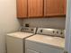 Functional laundry room with matching washer and dryer and above storage cabinets at 2461 Brooklyn Bridge St, Las Vegas, NV 89135