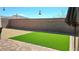 Backyard featuring a low-maintenance artificial grass lawn and a brick-paved patio area at 2629 Monte Cevedale St, Henderson, NV 89044