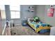 A bedroom features carpet flooring, window, small desk and a single bed with playful decor at 2629 Monte Cevedale St, Henderson, NV 89044