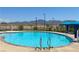 Community pool with clear blue water and mountain views on a sunny day with shade cabana and ladders for accessibility at 2629 Monte Cevedale St, Henderson, NV 89044