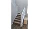 Carpeted staircase with white railing and wood-look floors, leading to the upper level of the home at 2629 Monte Cevedale St, Henderson, NV 89044