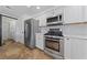 Modern kitchen with stainless steel appliances, white cabinets, and tile flooring at 2637 Rialto Rd, Las Vegas, NV 89108