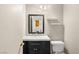 Cozy half bathroom with a dark vanity, framed mirror, and neutral paint at 2802 Secret Canyon Rd, Las Vegas, NV 89074